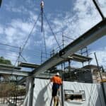 crane used at a house build, large beam being lifted into place